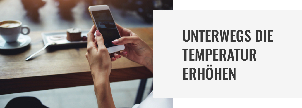 Frauenhände mit roten Fingernägelspitzen stellen etwas am Smartphone ein. Im Hintergrund, leicht verschwommen, ein Holztisch mit Kaffee und Kuchen Frauenhände mit roten Fingernägelspitzen stellen etwas am Smartphone ein. Im Hintergrund, leicht verschwommen, ein Holztisch mit Kaffee und Kuchen