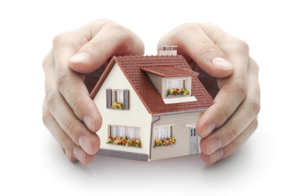 Zwei Hände die ein zwei Stöckiges miniatur Haus umhüllen Zwei Hände die ein zwei Stöckiges miniatur Haus umhüllen