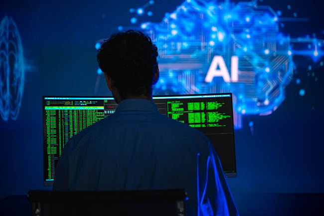Person arbeitet an mehreren Monitoren mit einer Darstellung künstlicher Intelligenz im Hintergrund